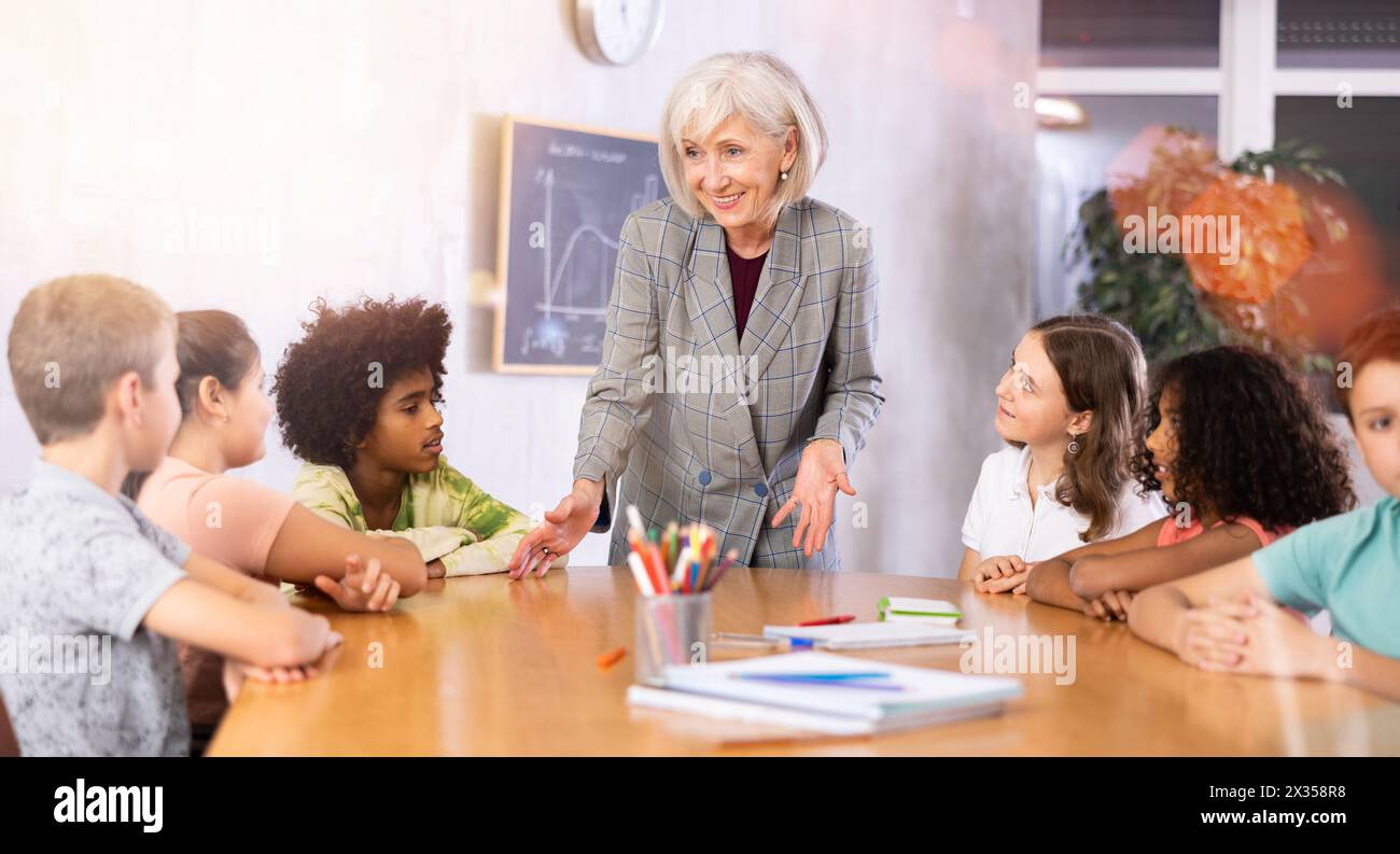 Female teacher giving kids a lesson in school classroom Stock Photo