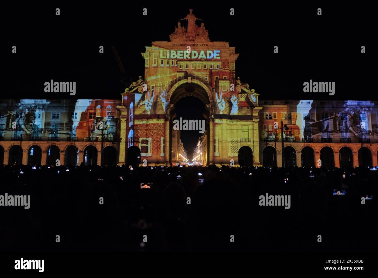 RECORD DATE NOT STATED 50 years of the Carnation Revolution videomapping concert in Lisbon In a vibrant display of color and sound, the spectacle Uma Ideia de Futuro lights up the city square of Terreiro do Paco in Lisbon. This videomapping show, featuring photographs by Alfredo Cunha and music by Rodrigo Leao, transforms the facades of the city into a canvas of light and color. Following the multimedia exhibition, the stage welcomes the Orquestra Sinfonietta de Lisboa, the Coro de Santo Amaro de Oeiras, the Coro da Escola Artistica do Instituto Gregoriano de Lisboa, and various soloists. Thes Stock Photo