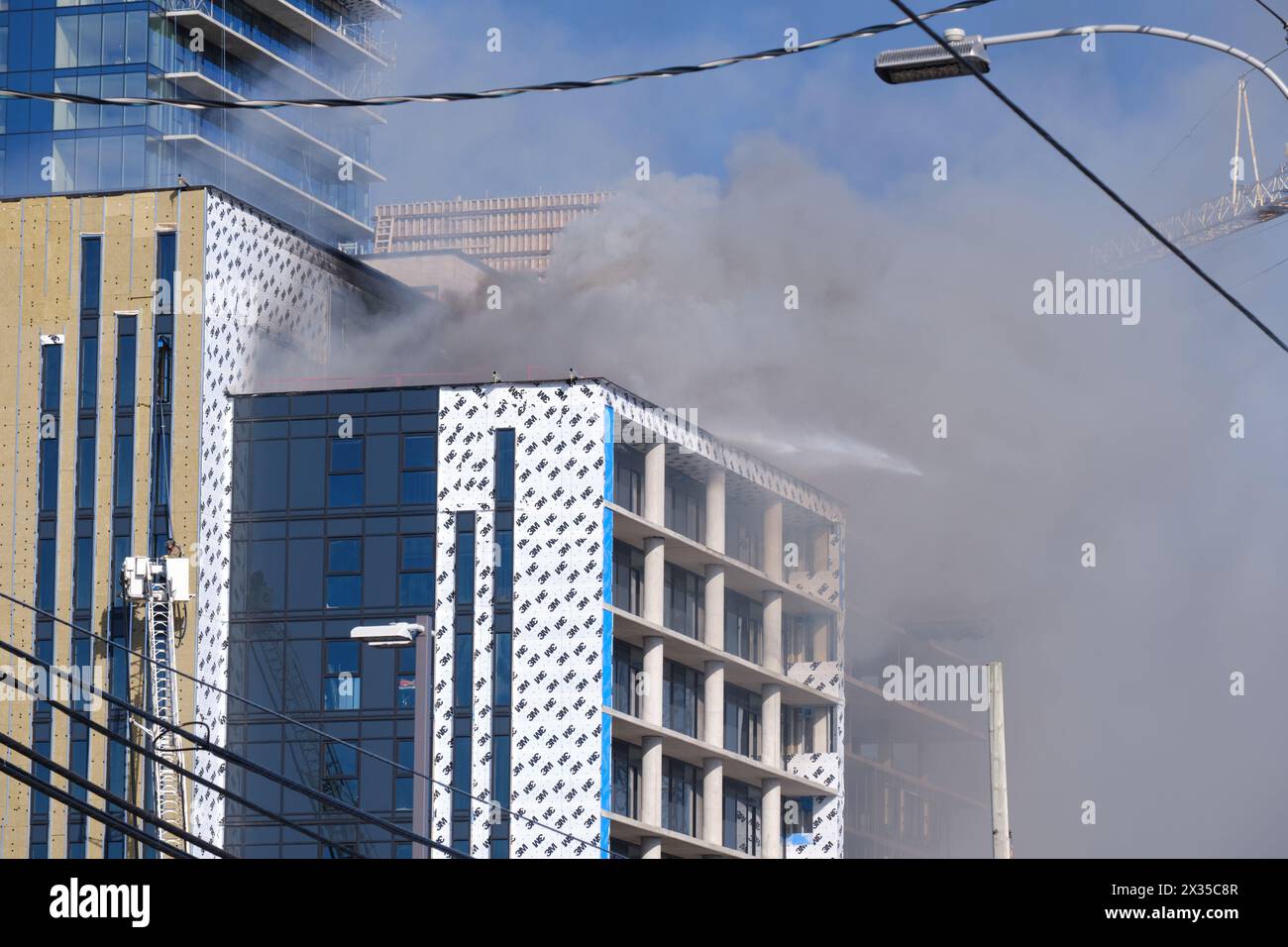Halifax, Nova Scotia. April 23, 2024.   Large fire of the roof of a new apartment building under construction on Robie street. Large cloud of black smoke seen from across the peninsula Stock Photo