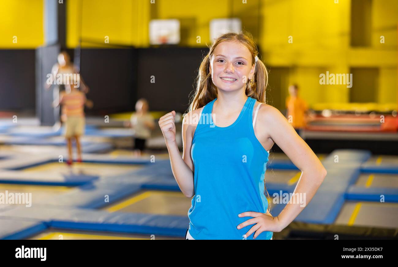 Happy teenage girl standing in indoor trampoline arena Stock Photo - Alamy