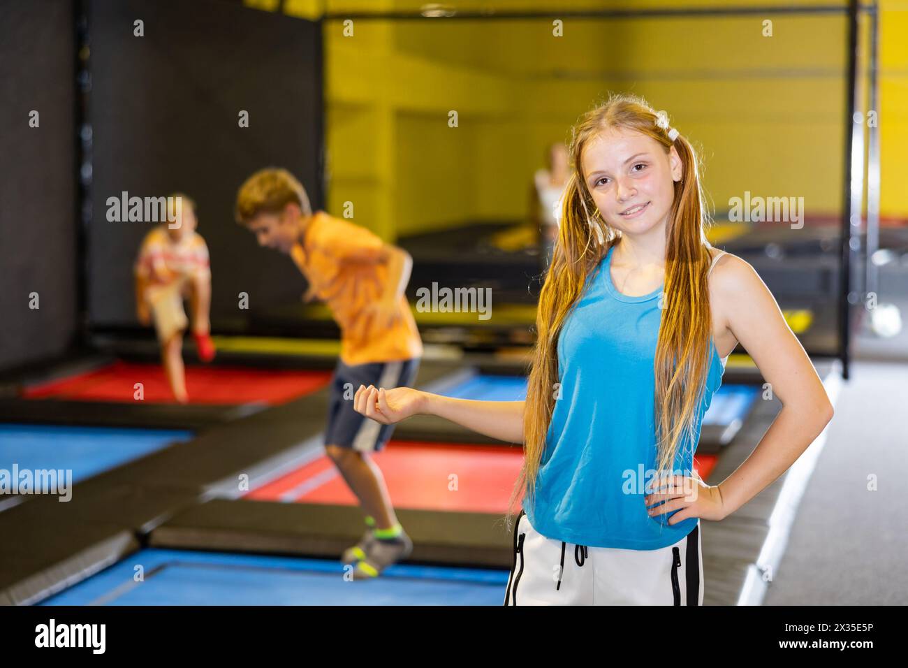Happy teenage girl standing in indoor trampoline arena Stock Photo - Alamy