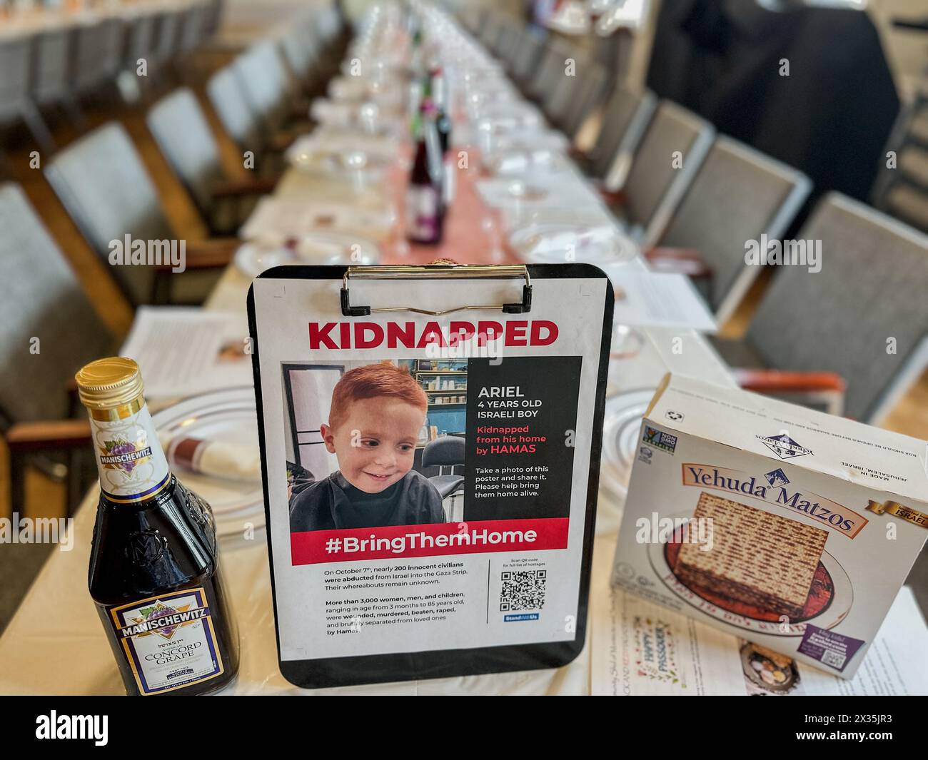 Montecito, California, U.S.A. 23rd Apr, 2024. A 'Kidnapped'' poster of Ariel, a four year old toddler kidnapped by Hamas, on a Passover table in Montecito, California, between a bottle of Kosher wine and a box of Matzos. This is hours before Jews will gather to celebrate Pesach ''” a ritual dinner where the story of how their ancestors in ancient times made the exodus from slavery in Egypt to freedom in Israel. The horrible attack by Hamas on Israel last fall and those hostages still being imprisoned in war-torn Palestine is a present day reminder of the bitterness of oppression, which is a Stock Photo