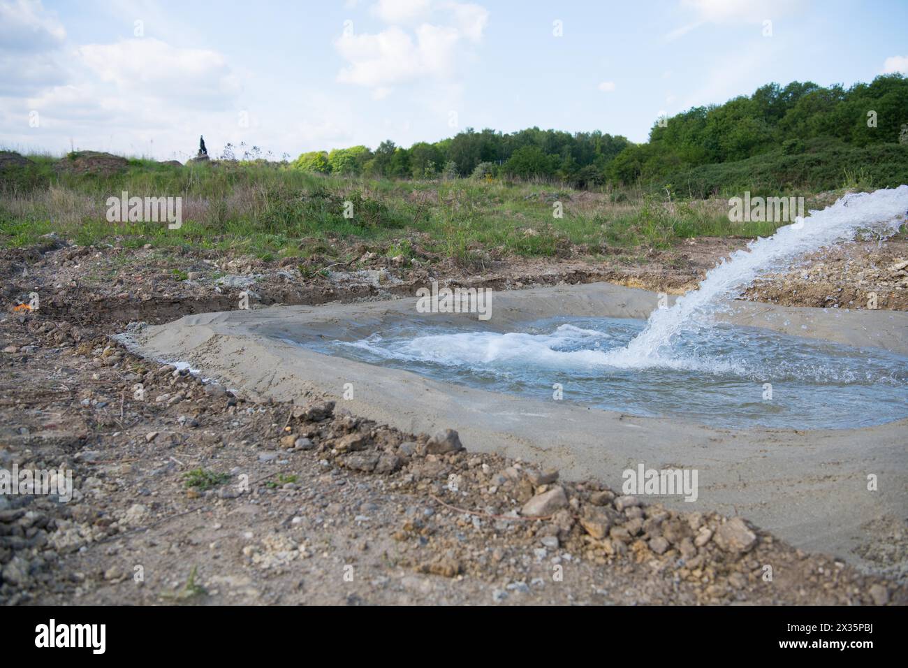 Species protection, newly created spawning waters for amphibians, tractor with water tank fills the new basin, Stolberg, North Rhine-Westphalia Stock Photo