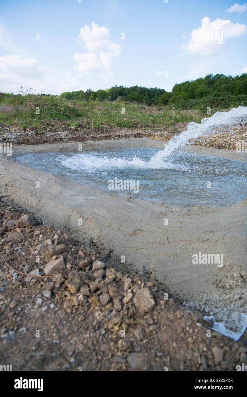 Species protection, newly created spawning waters for amphibians, tractor with water tank fills the new basin, Stolberg, North Rhine-Westphalia Stock Photo