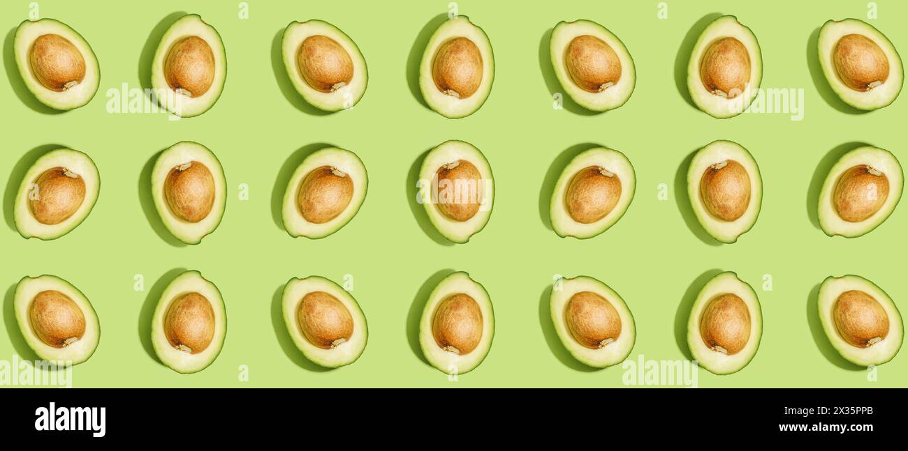 Many halves of fresh ripe avocados on green background. Pattern for ...
