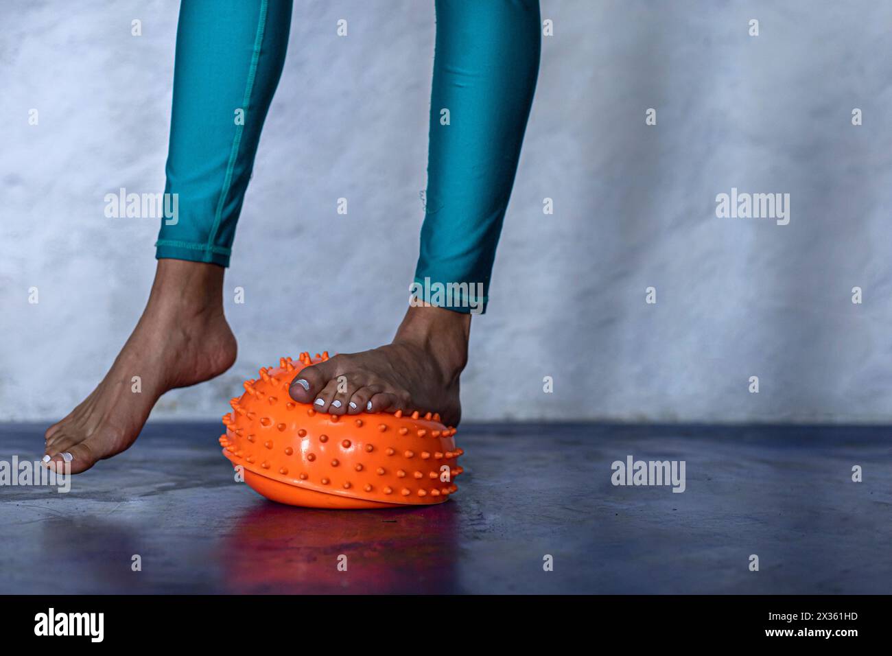 Young Latin American woman (25) barefoot balancing on a spiked massage