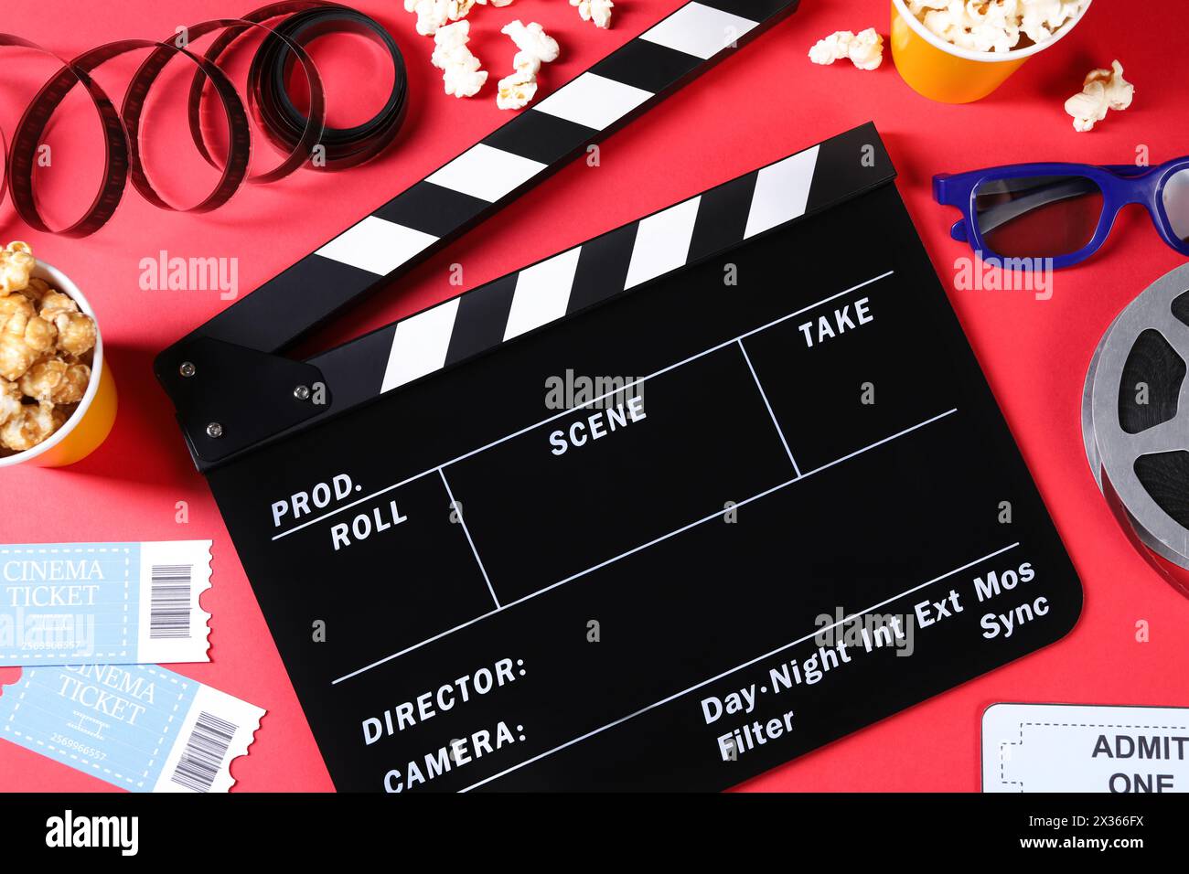 Flat lay composition with clapperboard and popcorn on red background Stock Photo