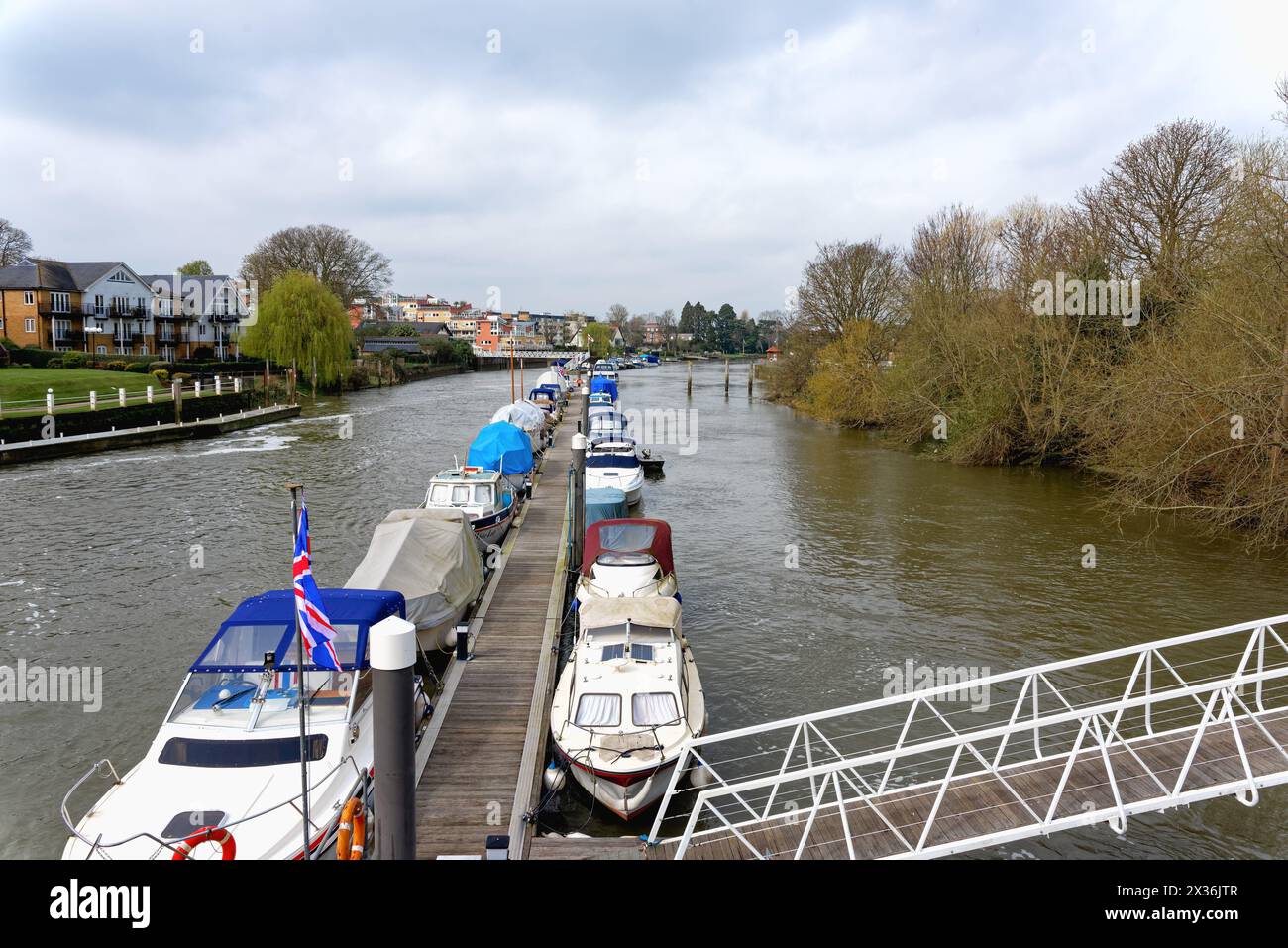The River Thames at Teddington lock with modern waterside apartments and moored boats Greater London England UK Stock Photo
