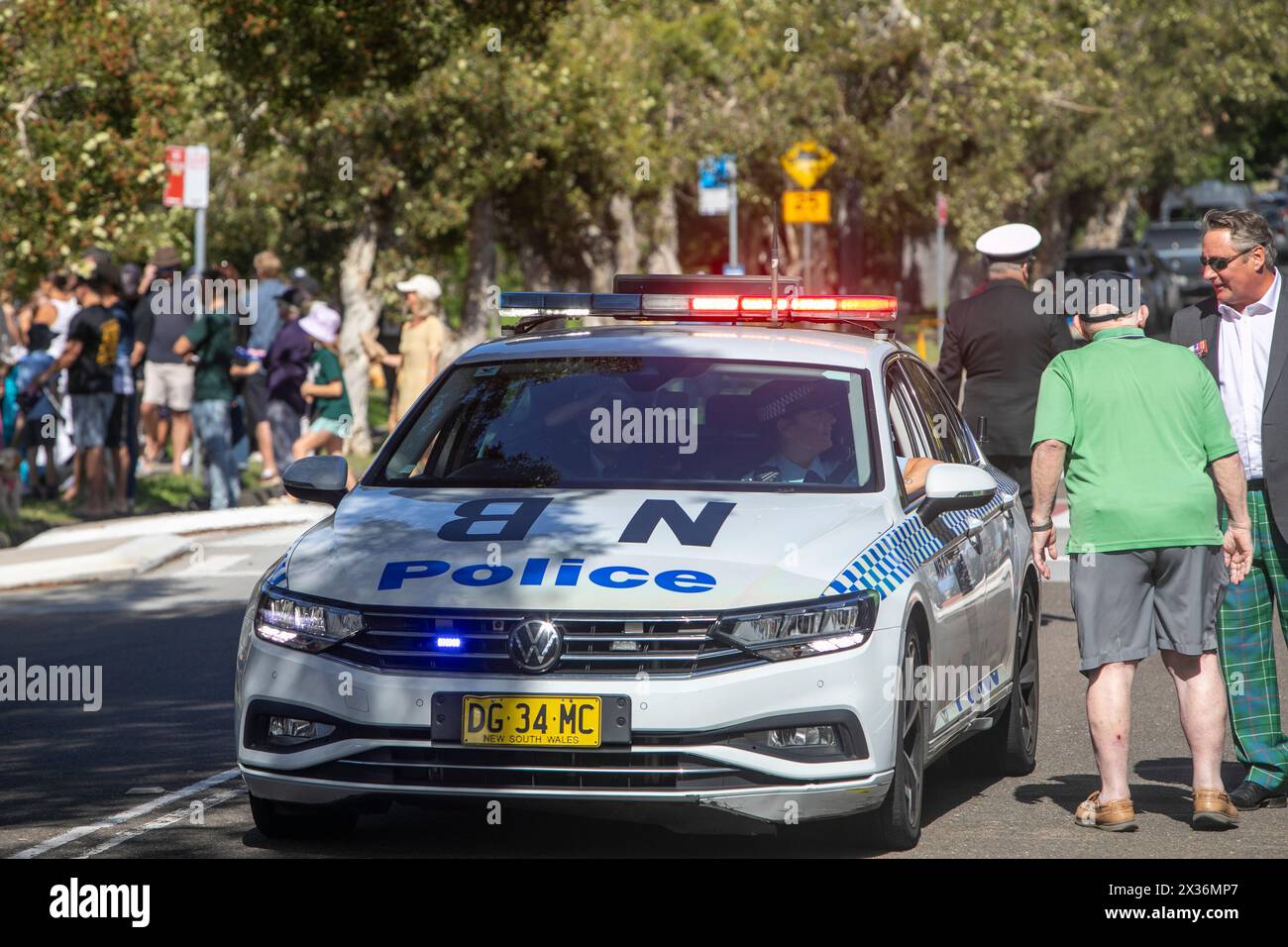 ANZAC Day 2024, Sydney police car and officers prepare to lead the parade through Avalon Beach suburb of Sydney,NSW,Australia, with police lights on Stock Photo