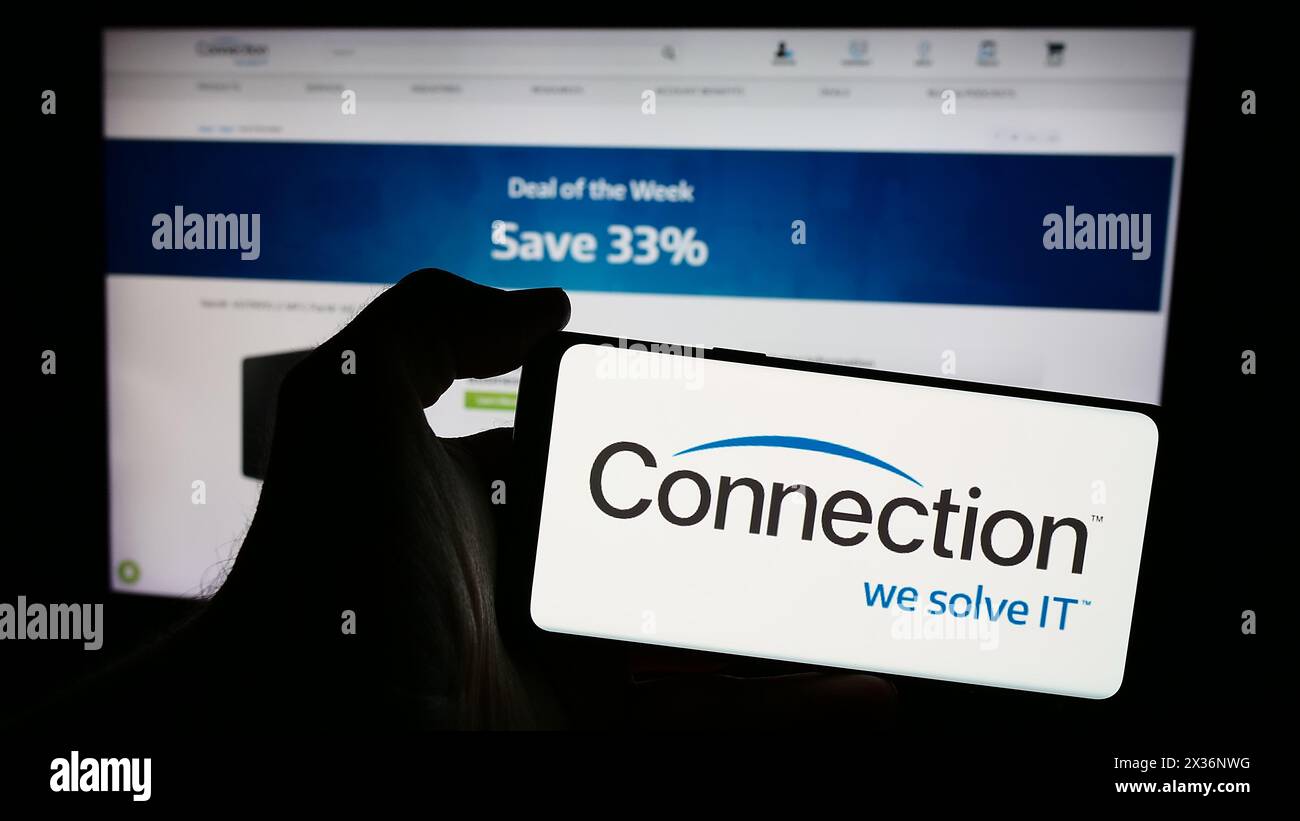 Person holding smartphone with logo of US information technology company PC Connection Inc. in front of website. Focus on phone display. Stock Photo