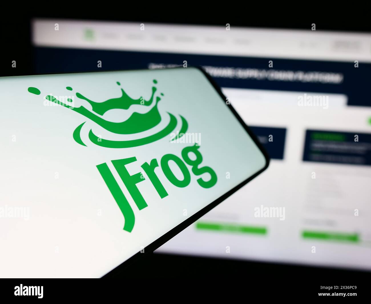 Smartphone with logo of American software development company JFrog Ltd. in front of business website. Focus on center-left of phone display. Stock Photo