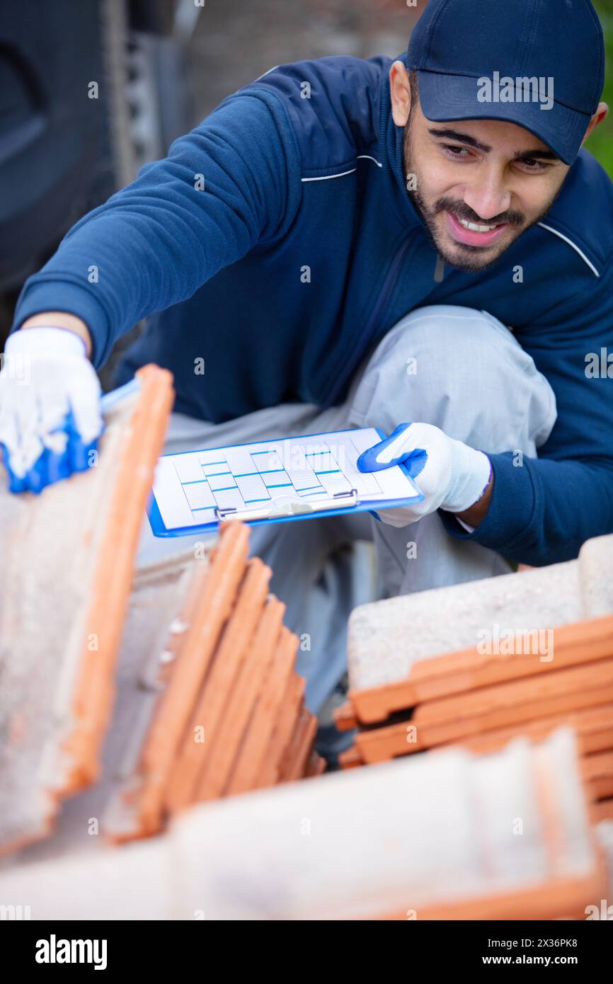 worker with clipboard checking construction materials Stock Photo