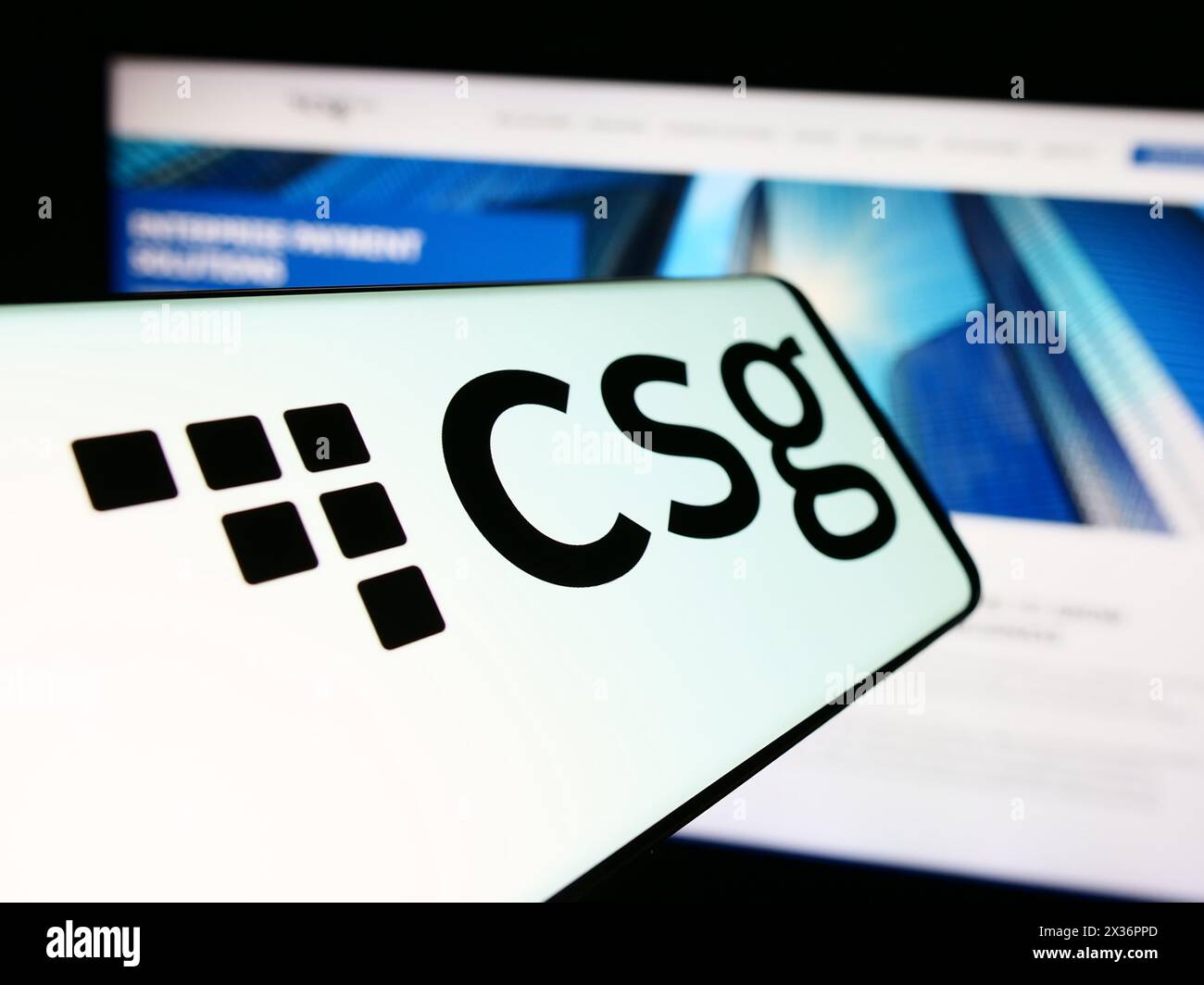 Cellphone with logo of American BSS software company CSG Systems Inc. in front of business website. Focus on center-left of phone display. Stock Photo