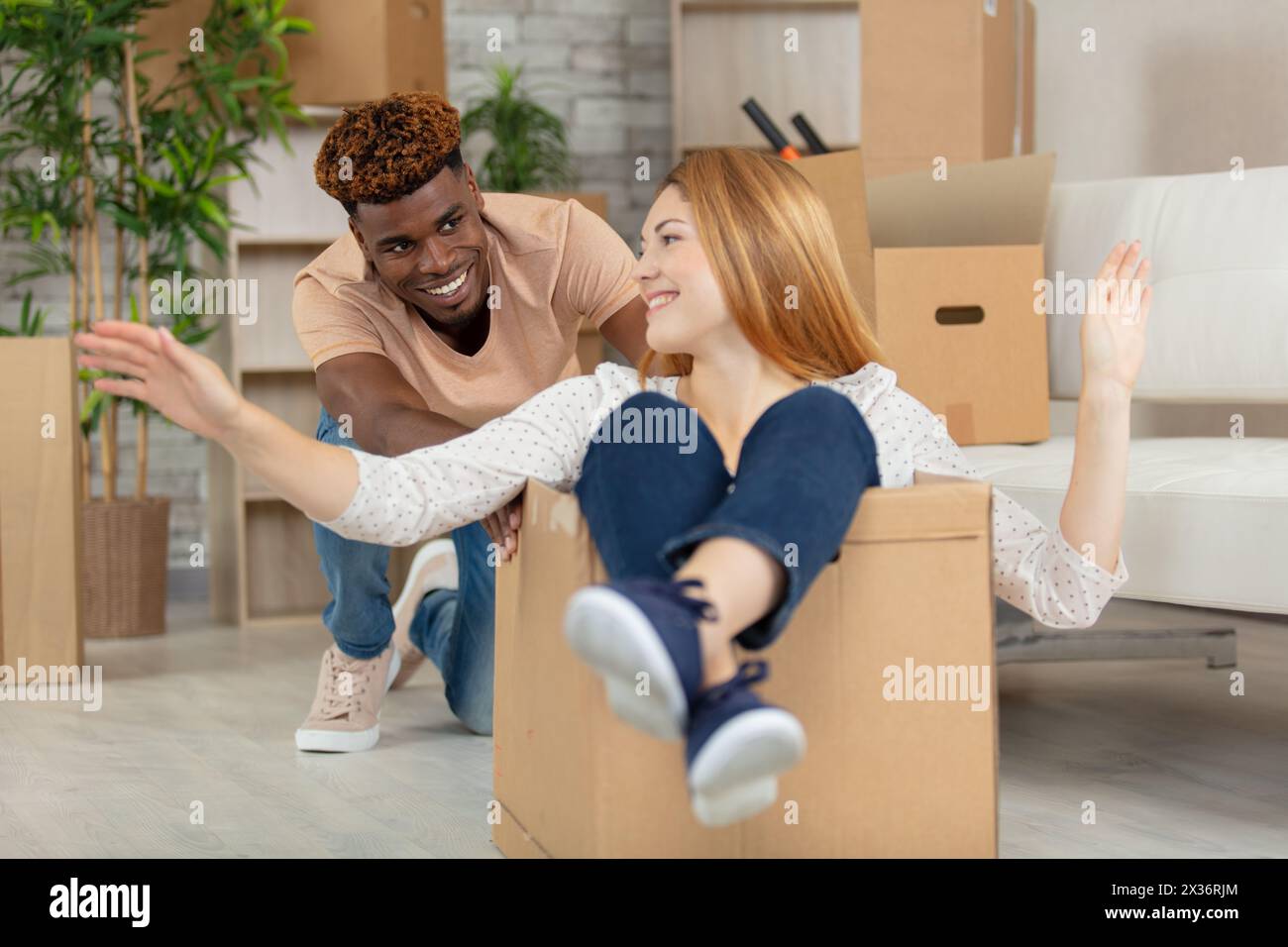 mixed couple having fun with cardboards Stock Photo