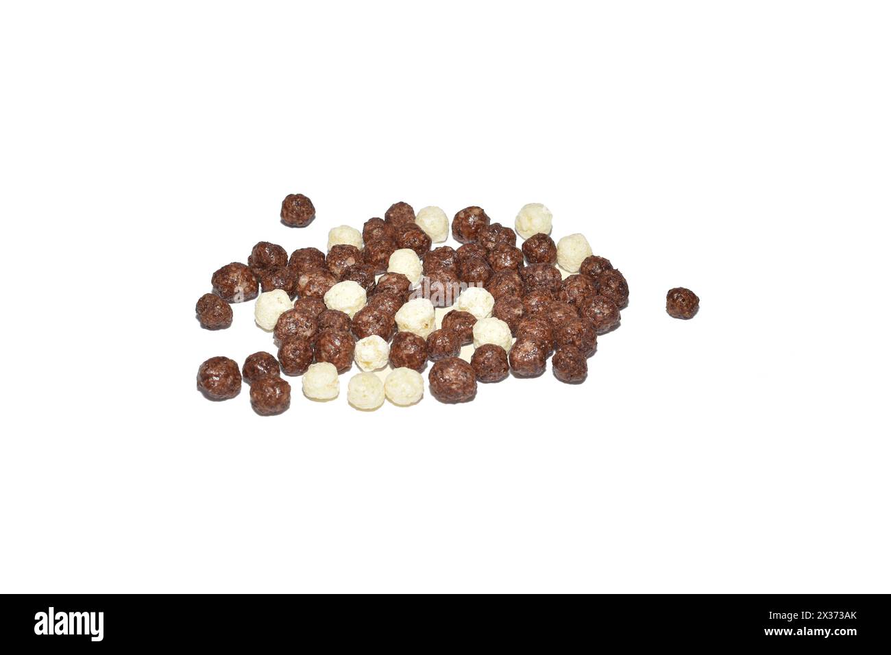 Corn balls with chocolate and vanilla flavors are scattered on a white background for a hearty breakfast. Stock Photo