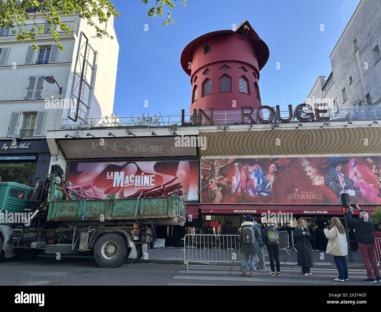 France. 25th Apr, 2024. © PHOTOPQR/LE PARISIEN/LP/Delphine Goldsztejn ; ; 25/04/2024 ; Les ailes du célèbre cabaret parisien du quartier de Pigalle sont tombées au sol pendant la nuit de mercredi à jeudi. Trois lettres de l'enseigne ont aussi été emportées. Aucun blessé n'est toutefois à déplorer. Moulin Rouge Workers work to secure the area in front of the cabaret after the blades of the Moulin Rouge windmill collapsed during the night without causing any injuries in Paris, on April 25, 2024 Credit: MAXPPP/Alamy Live News Stock Photo