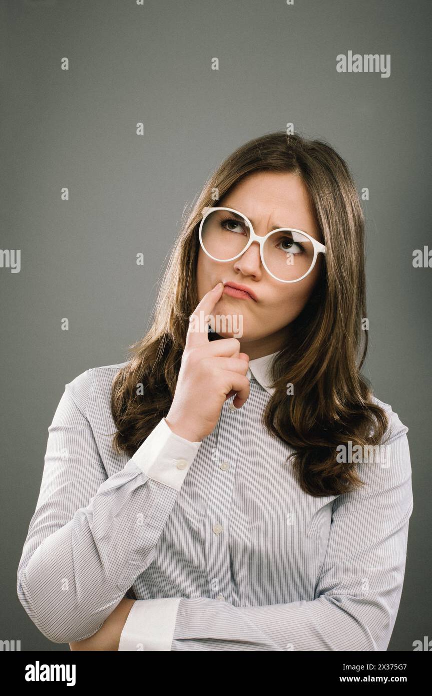 Girl, student and thinking with glasses in studio for education, exam ...