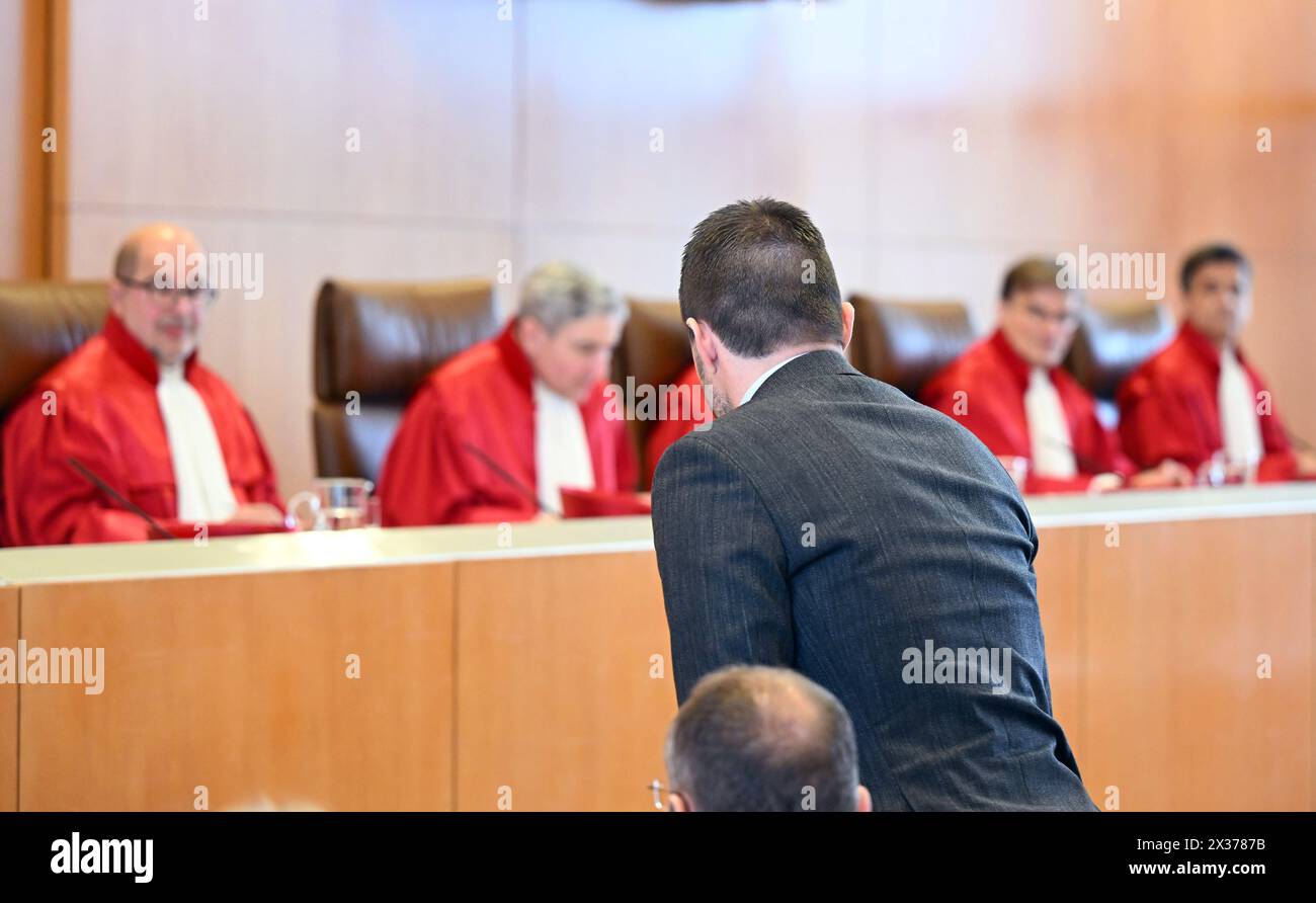 Karlsruhe, Germany. 25th Apr, 2024. Marc Lenz (l), Managing Director of the German Football League (DFL) takes part in the hearing at the Federal Constitutional Court on whether the German Football League (DFL) may be charged for police costs for high-risk matches. The First Senate, (l-r) Heinrich Amadeus Wolff, Stephan Harbarth, Chairman of the Senate and President of the Court, Yvonne Ott, Henning Radtke and Martin Eifert, can be seen in the background. Credit: Uli Deck/dpa/Alamy Live News Stock Photo