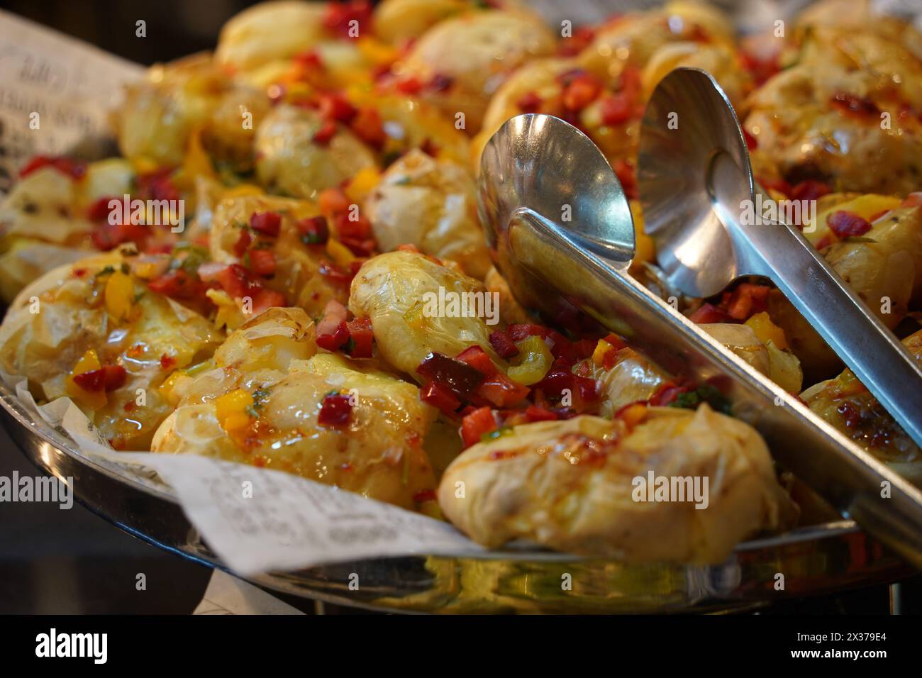 Whole baked potatoes with vegetables and oil close up Stock Photo