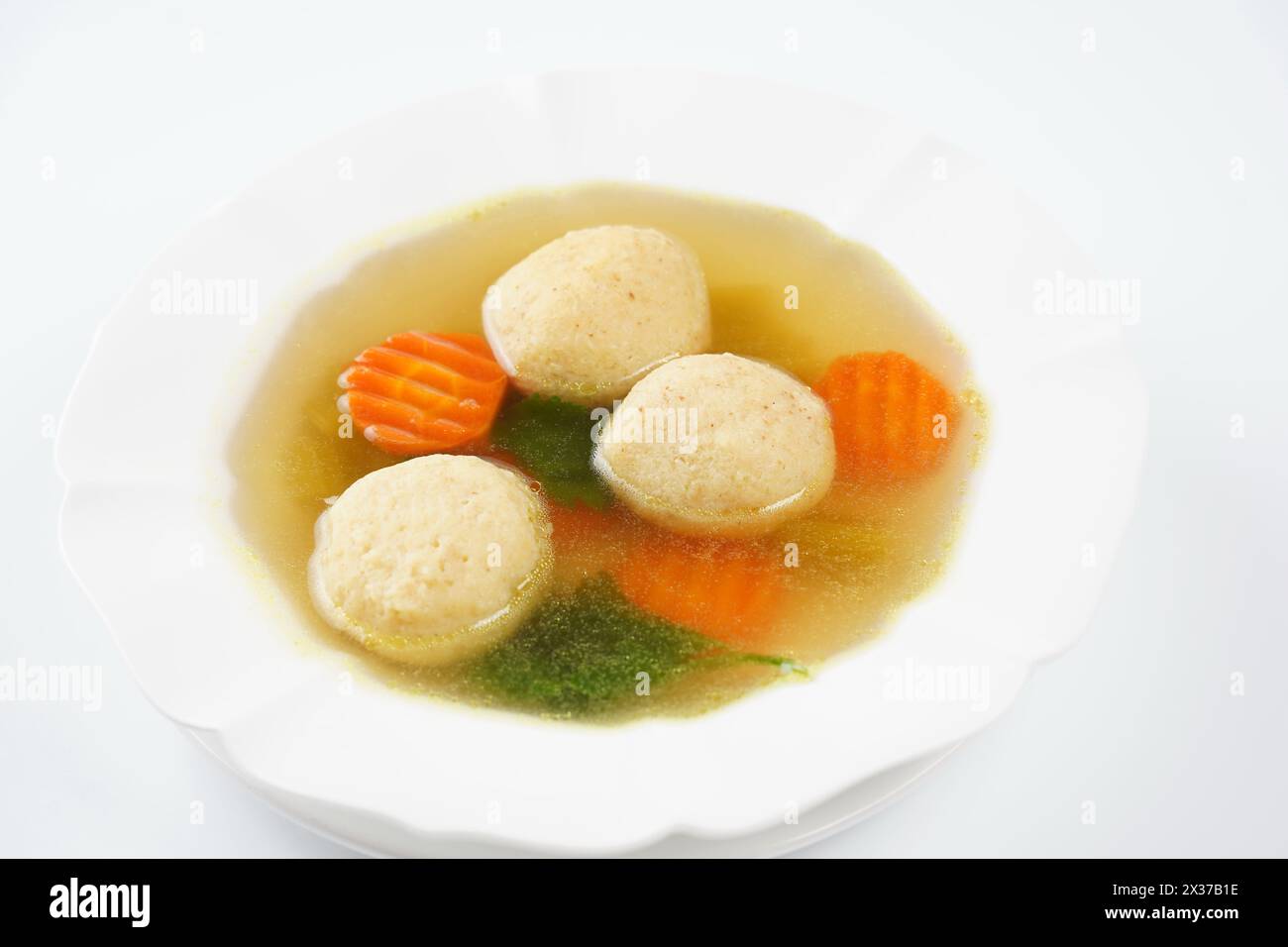 Jewish chicken broth with kneidlach (balls made with matzo meal). Matzo ball soup Stock Photo