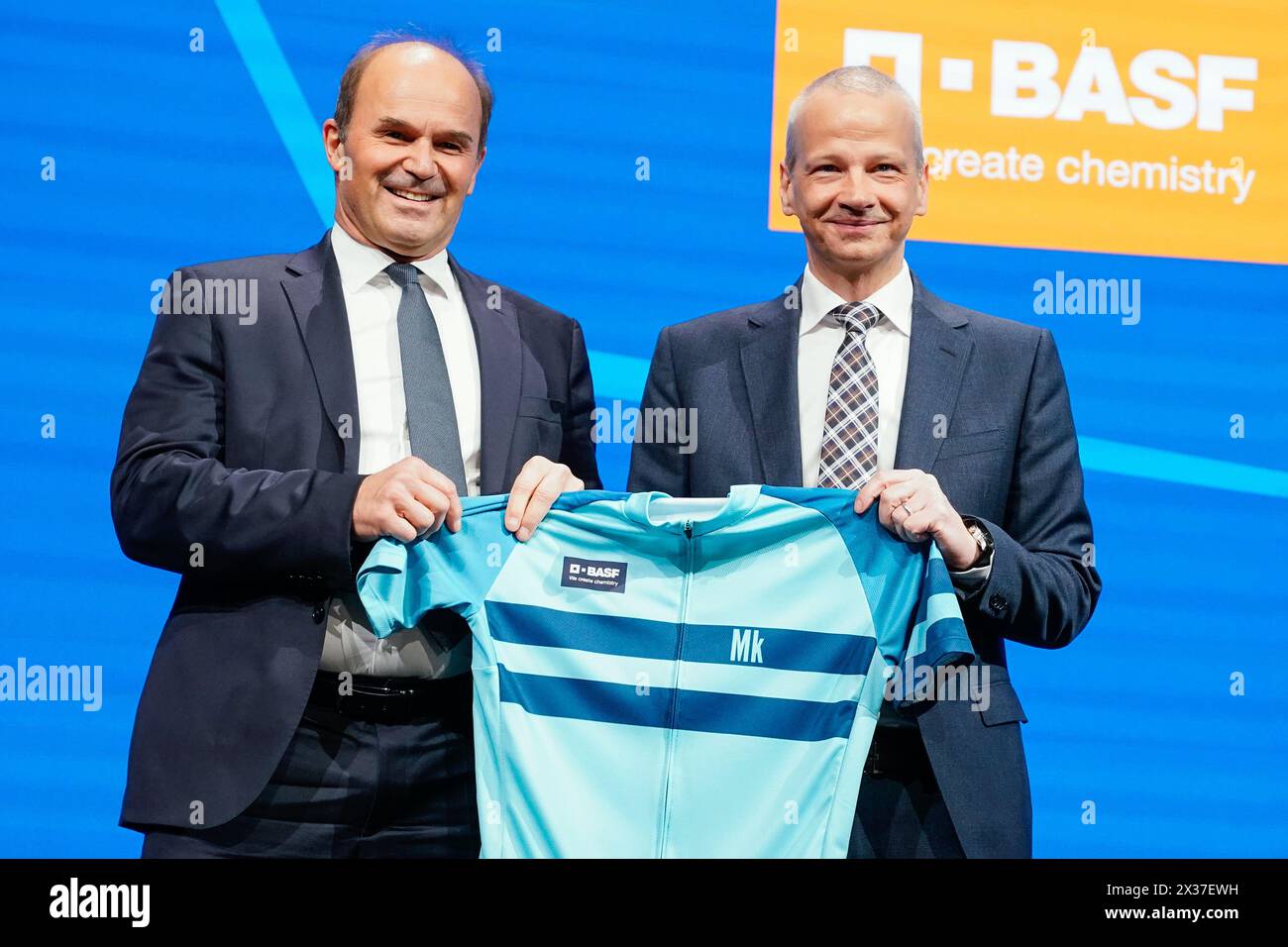 Mannheim, Germany. 25th Apr, 2024. Martin Brudermüller (l), Chairman of the Board of Executive Directors of BASF SE, hands over a cycling jersey to Markus Kamieth, future Chairman of the Board of Executive Directors of BASF SE, at the Annual Meeting of the chemical company BASF. It is the last shareholders' meeting of Chairman Brudermüller. Kamieth will take office at the end of the Annual Meeting. Credit: Uwe Anspach/dpa/Alamy Live News Stock Photo