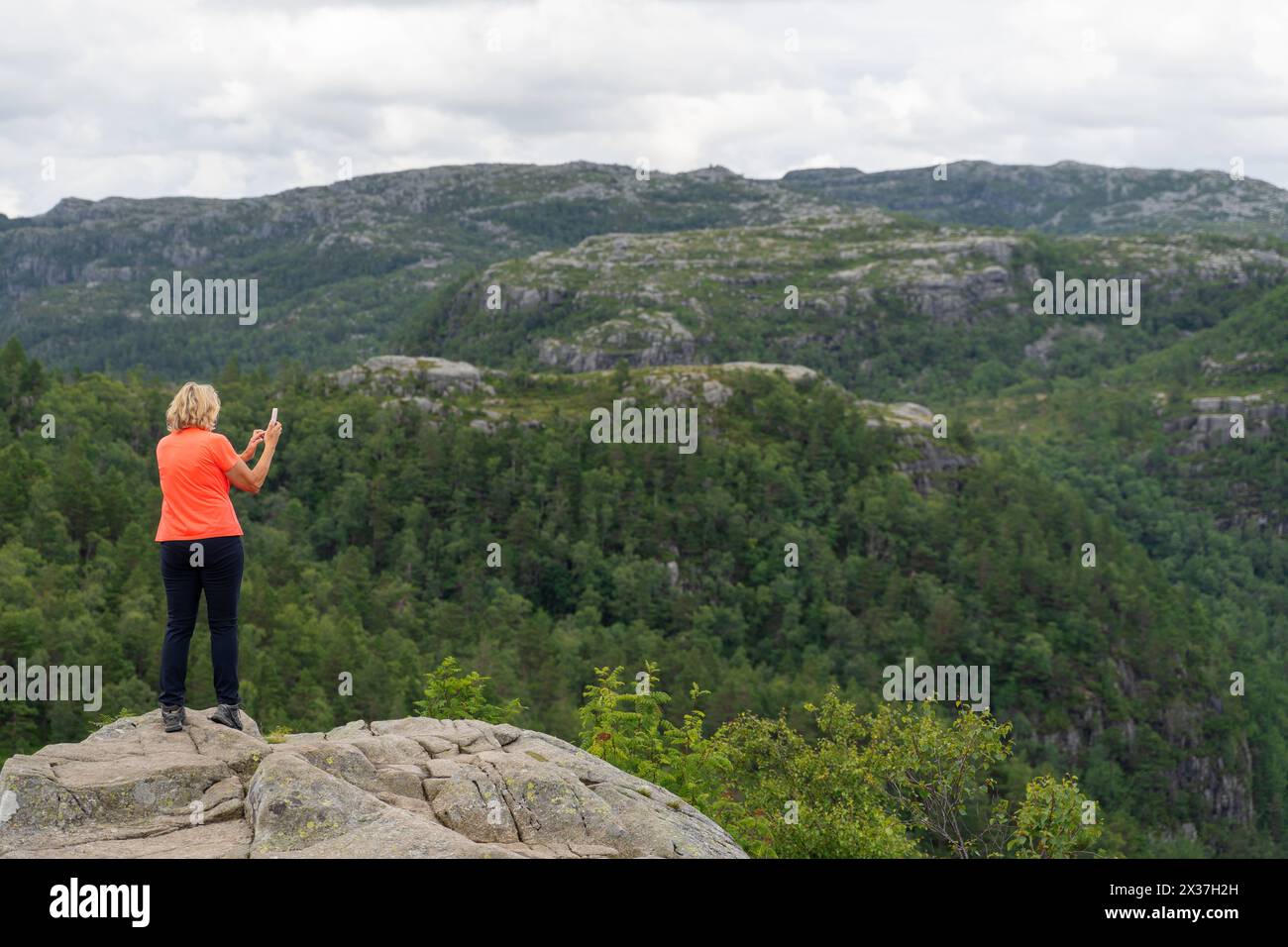 Norway - July 14, 2023: Woman takes a photo of nature with her cell phone in Norway *** Frau macht in Norwegen mit dem Handy ein Foto von der Natur Stock Photo