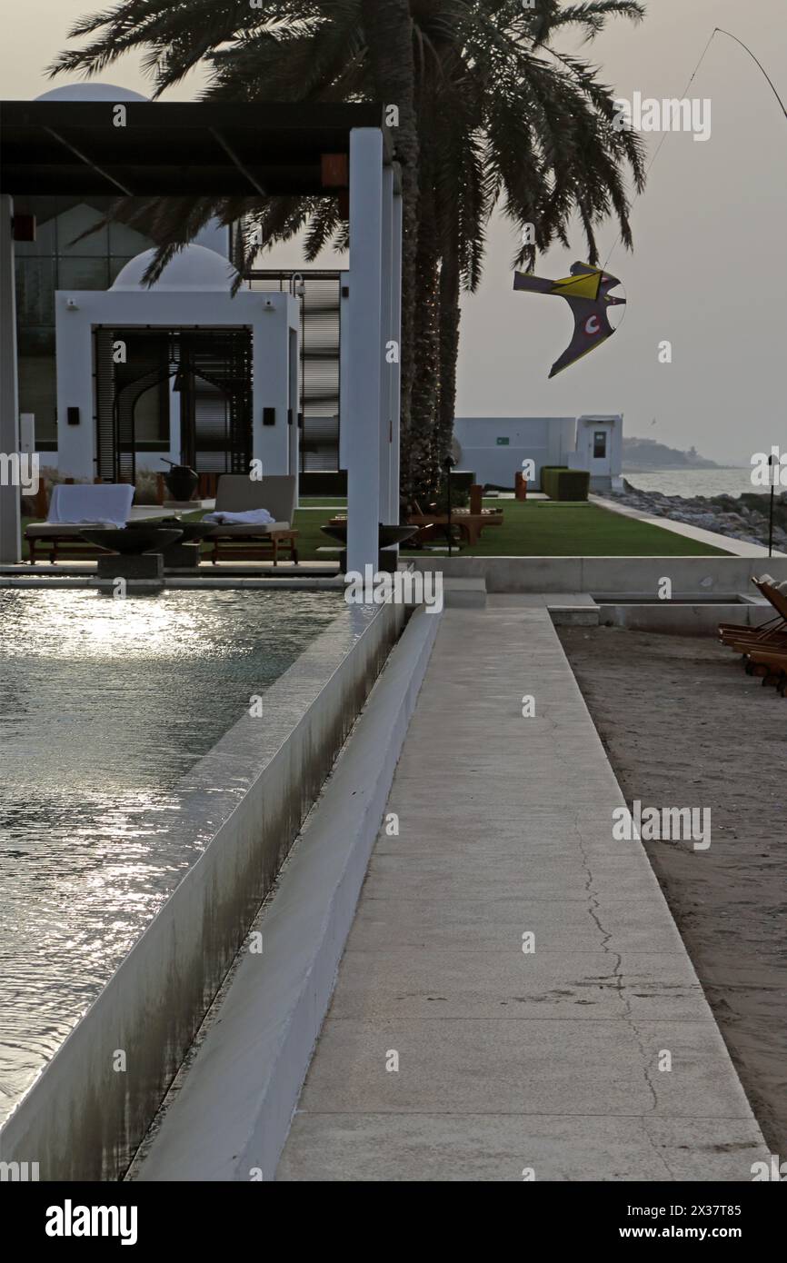 Hawk Scarer Kite used as a Deterrent to Birds Flying Above Infinity Pool By Walkway at The Chedi Hotel Muscat Oman Stock Photo