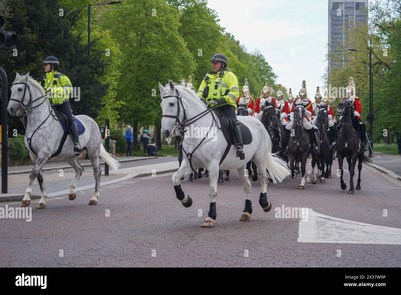 London, UK. 25th April, 2024. Mounted police escort  members  of the Household cavalry mounted division as they  leave Knightsbridge barracks  for the Major General's inspection  . On wednesday  it  was reported a number of cavalry horses were spooked by the noise of builders moving concrete, causing them to bolt and unseat the riders and colliding with vehicles and causing a number of injuries.  Credit: amer ghazzal/Alamy Live News Stock Photo