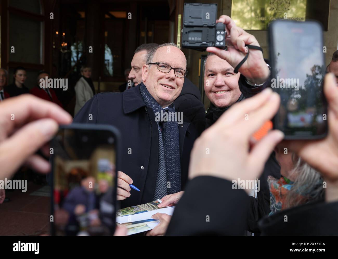 Hamburg, Germany. 25th Apr, 2024. Albert II. Prince of Monaco signs autographs and has his photo taken on his arrival at the Hotel Vier Jahreszeiten. The royal family attends the opening of the new Monaco World at Miniatur Wunderland in Hamburg. Credit: Christian Charisius/dpa/Alamy Live News Stock Photo