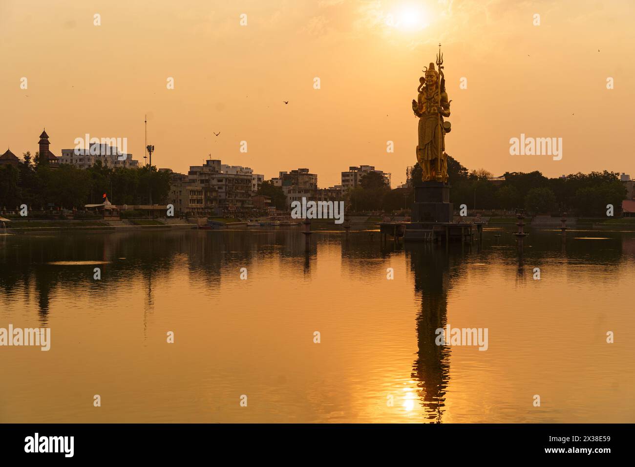 The Statue of Hindu god Lord Shiva in Sursagar Lake is seen at sunset