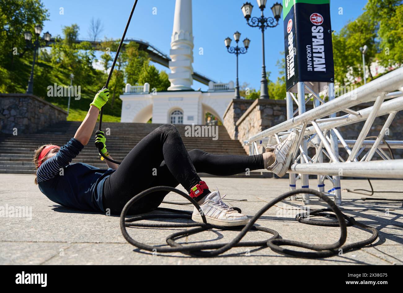 Young woman lifts heavy weight on a Hercules hoist at the Spartan Race