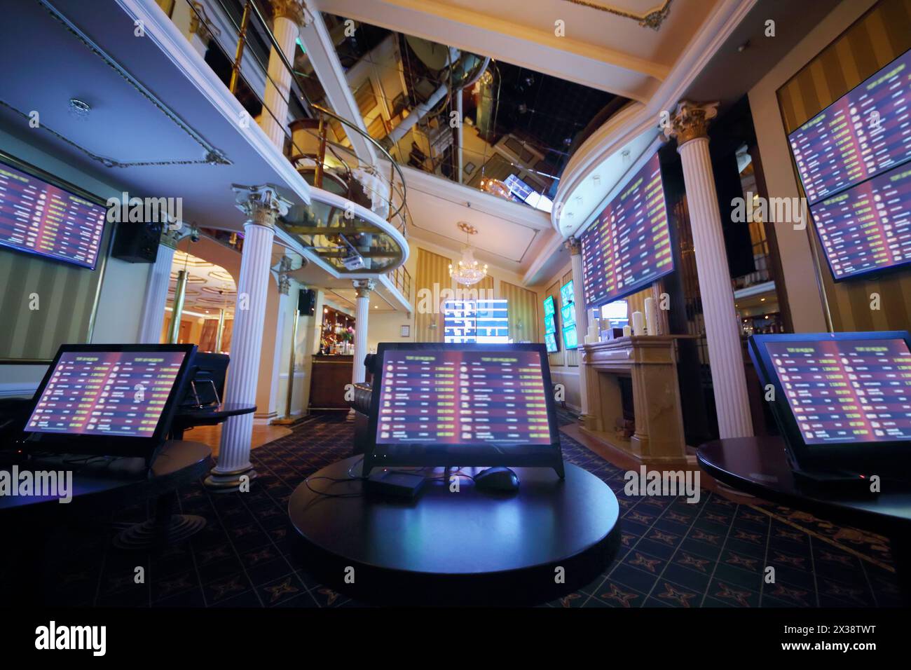 Hall with lot of screens in luxury bookmaker office, tables with gaming computers, my photo on displays Stock Photo