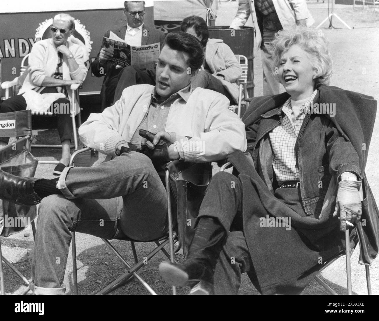 ELVIS PRESLEY and BARBARA STANWYCK relaxing on the set of ROUSTABOUT 1964 Director JOHN RICH Costume Design EDITH HEAD Director of photography LUCIEN BALLARD A Hal Wallis Production / Paramount Pictures Stock Photo