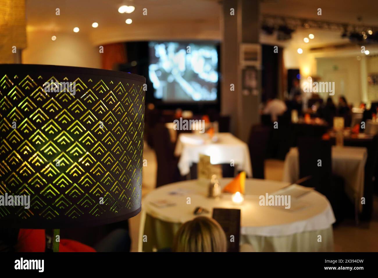 Lampshade and people sitting in restaurant, at evening, focus on lamp Stock Photo
