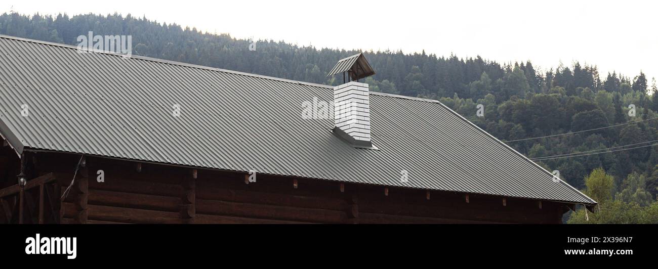roof covered with metal tiles, roofing, wooden house. Stock Photo