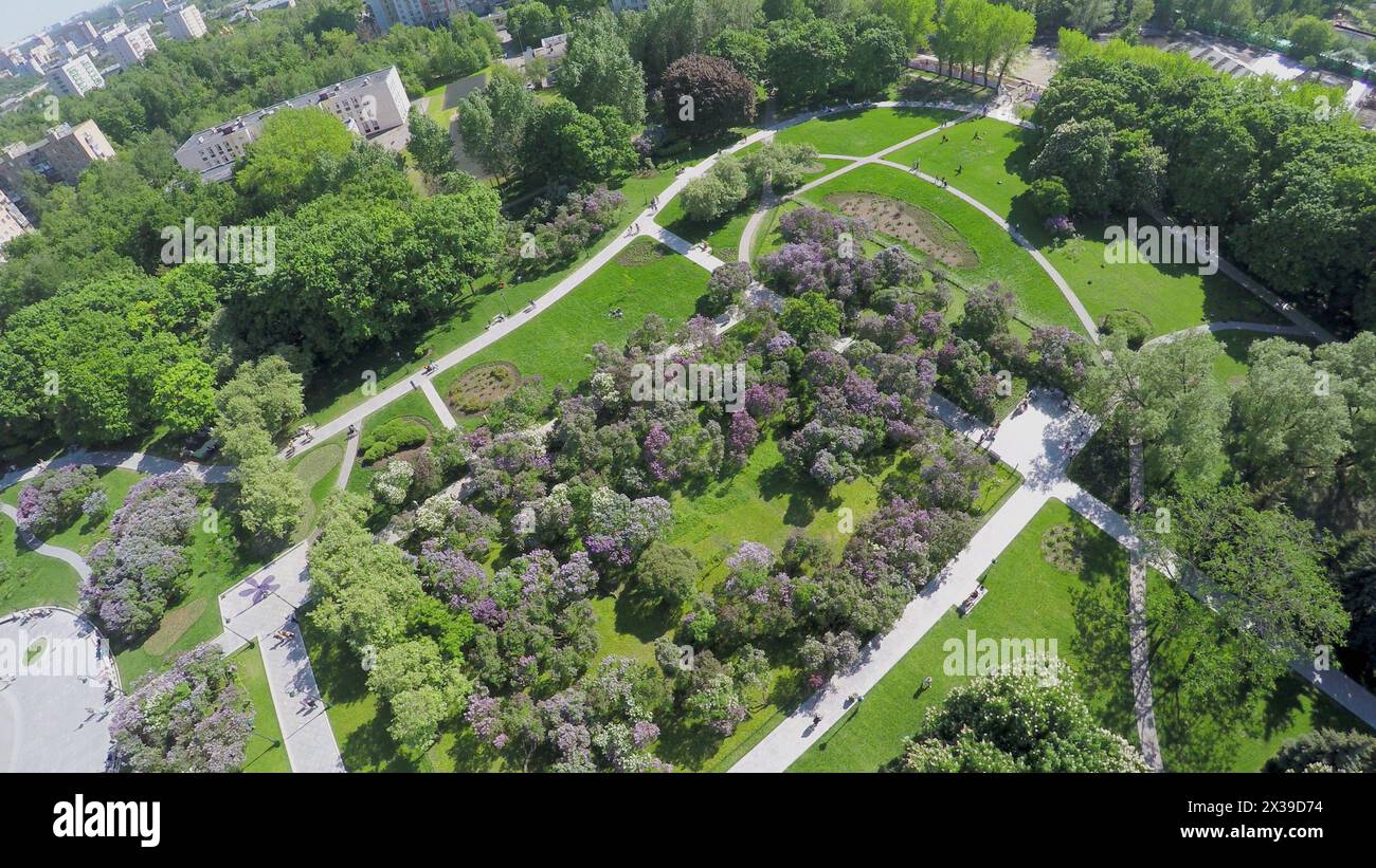 Citizens get rest in Lilac Garden near Dry Fountain at spring sunny day. Aerial view Stock Photo