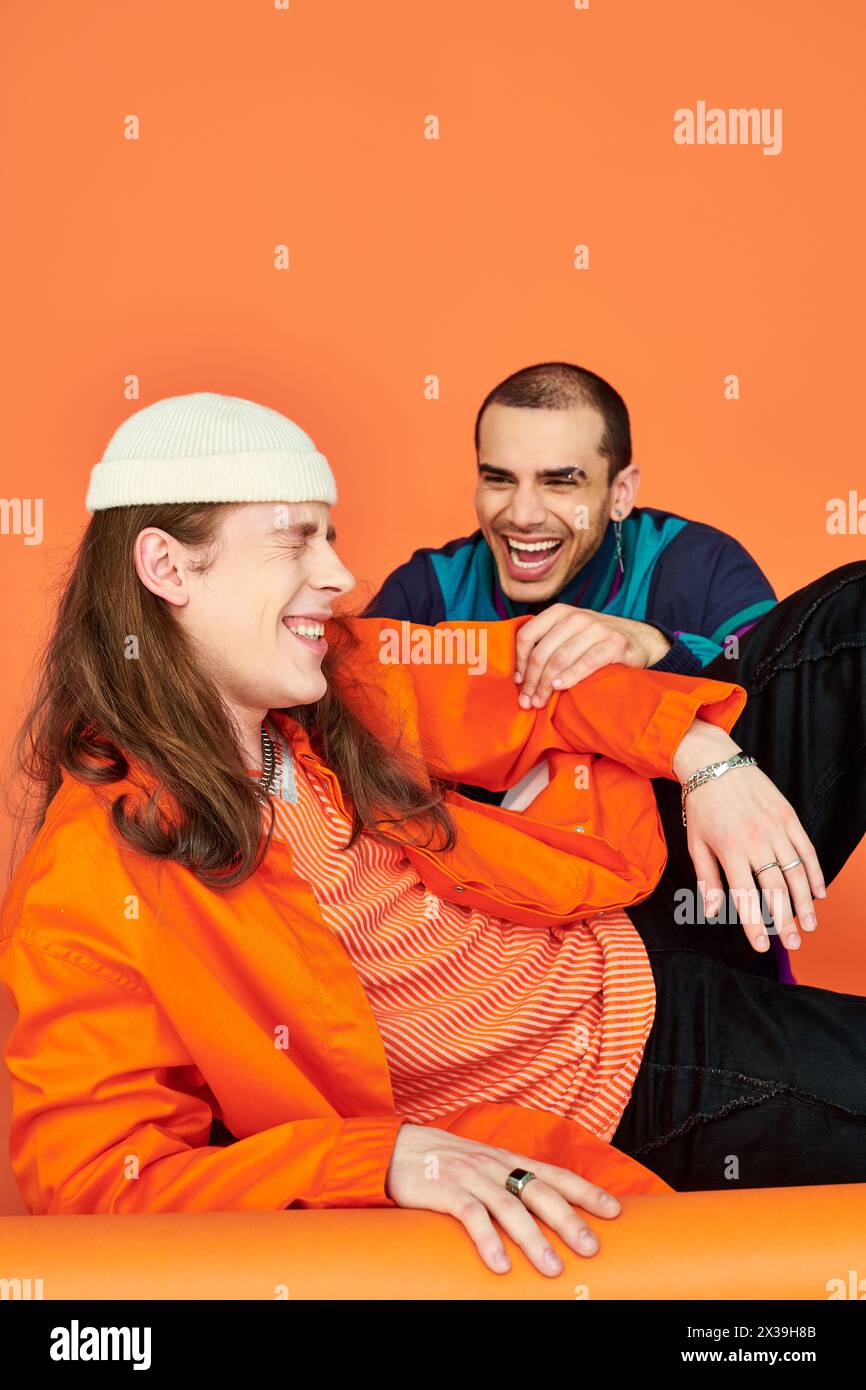 Two men sitting on the floor, sharing a moment of laughter. Stock Photo