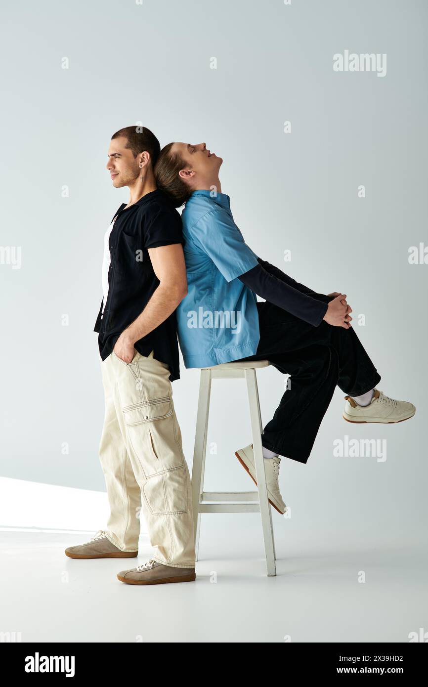 Two men peacefully sitting together on a stool. Stock Photo