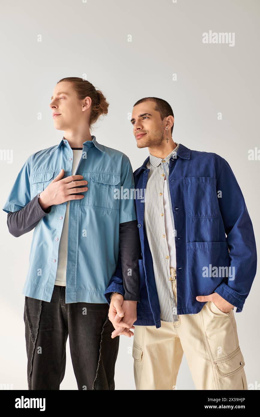 Two young men, a loving gay couple, stand side by side. Stock Photo