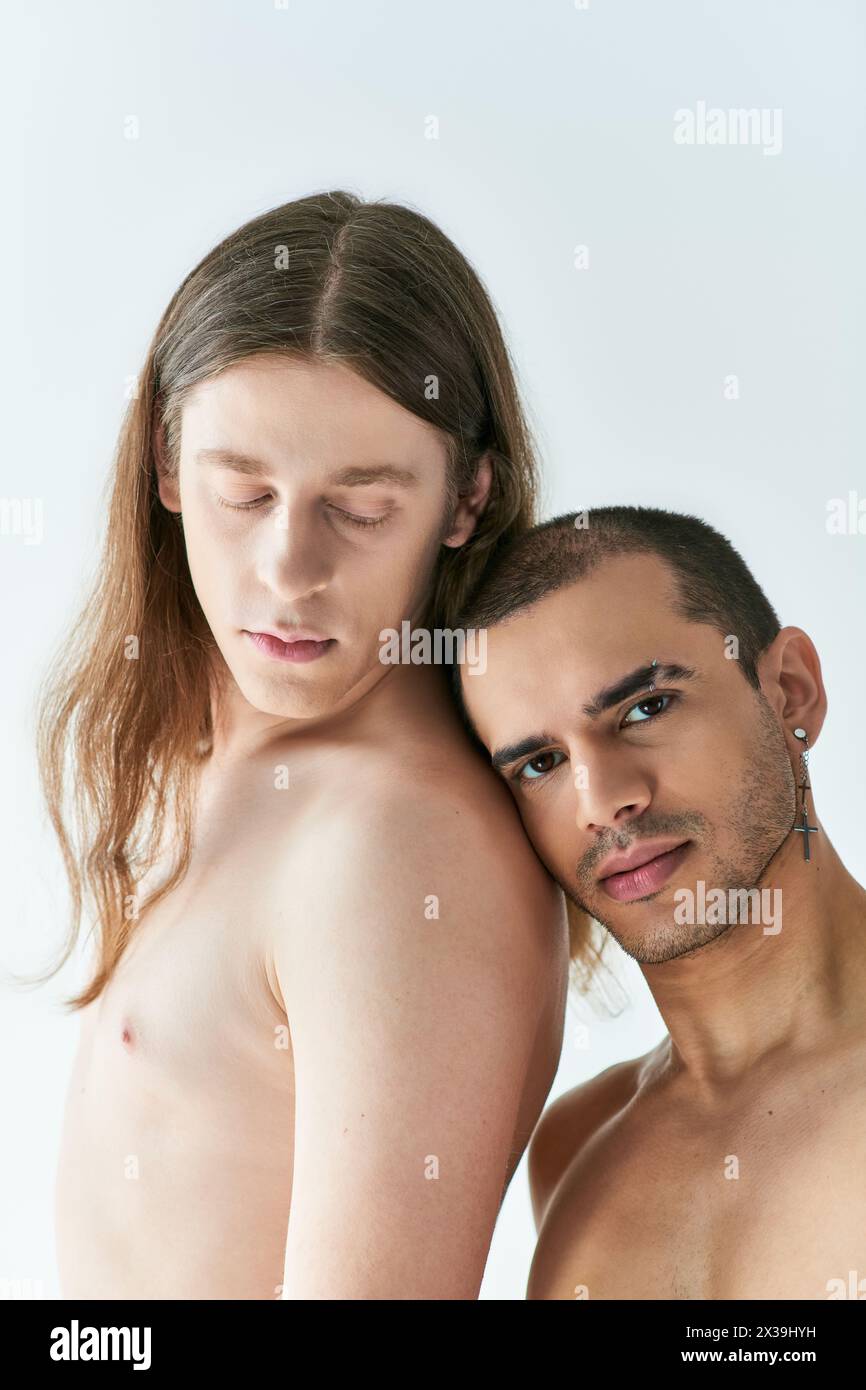 A pair of men standing closely beside each other. Stock Photo