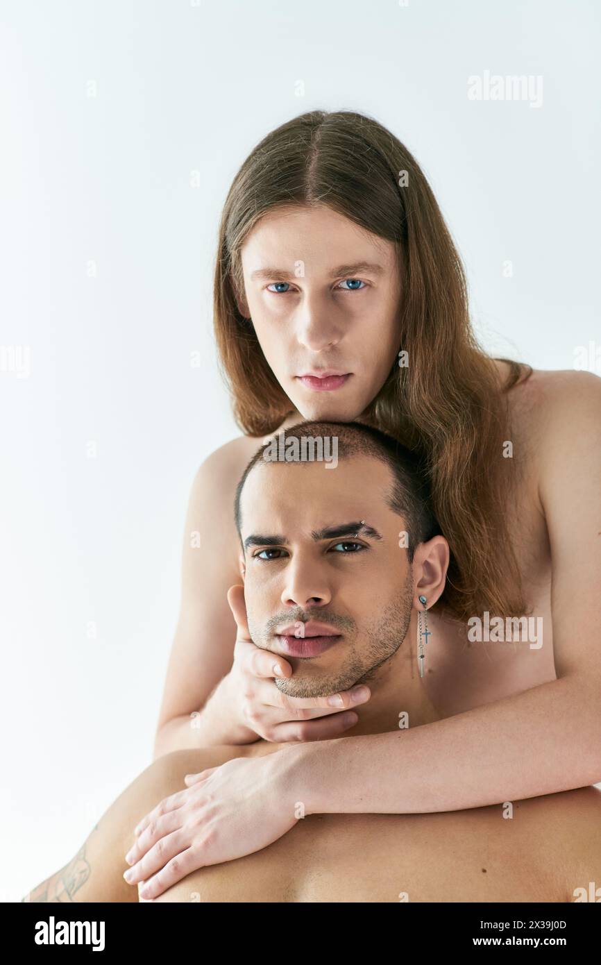 A man tenderly holds his boyfriend in his arms. Stock Photo