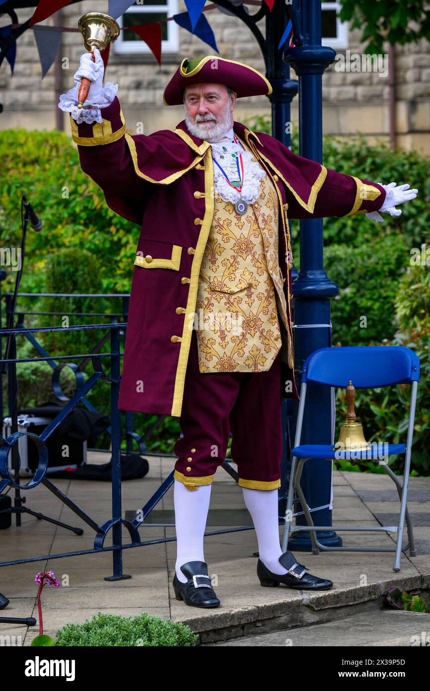 Male town crier & bellman (awarded 1st prize winner's medal) making loud noisy public proclamation announcement - Ilkley, West Yorkshire, England UK. Stock Photo