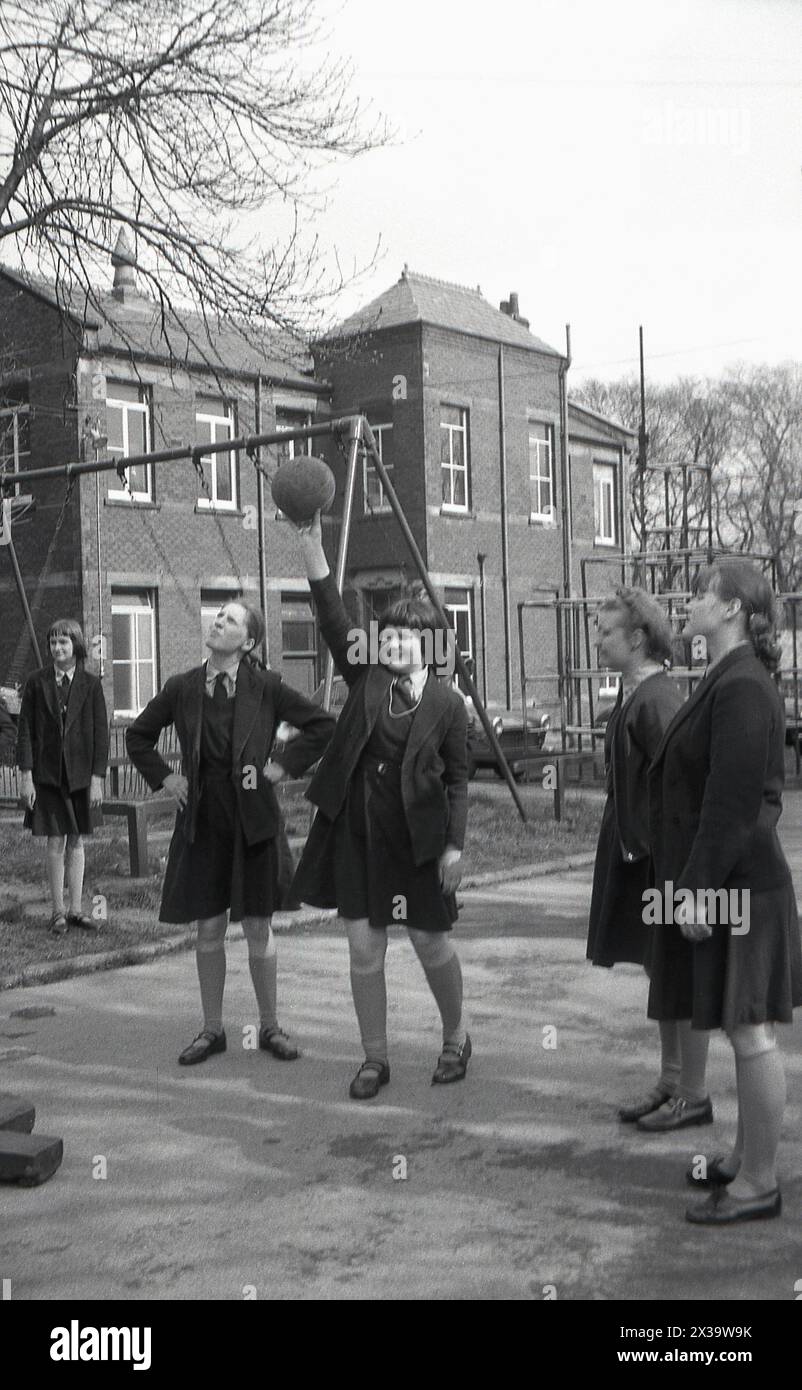1970s, historical, schoolgirls playing netball outside in the school playground, England, UK. Stock Photo