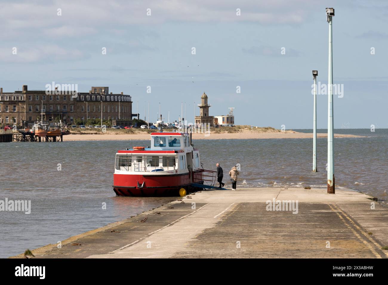 The ferry waits to depart from the slipway at Knott End-on-Sea, across the estuary to Fleetwood, Lancashire. The scene was painted by L. S. Lowry. Stock Photo