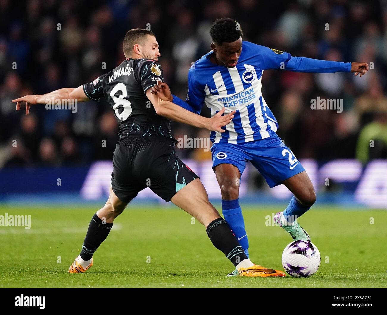 Manchester City's Mateo Kovacic (left) and Brighton and Hove Albion's Simon Adingra battle for the ball during the Premier League match at the American Express Stadium, Brighton. Picture date: Thursday April 25, 2024. Stock Photo