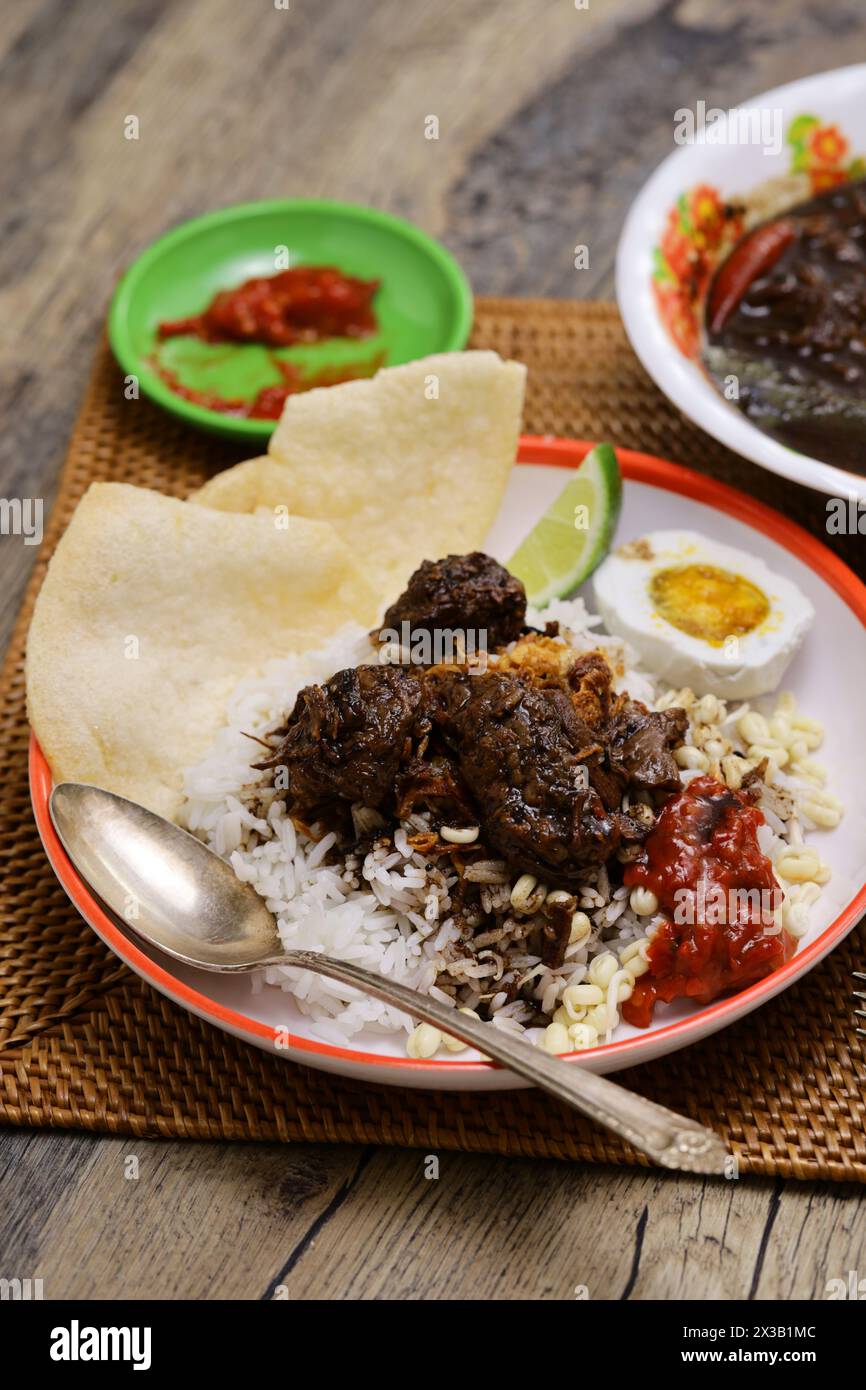 nasi rawon, black beef soup with rice.  Indonesian cuisine. Stock Photo