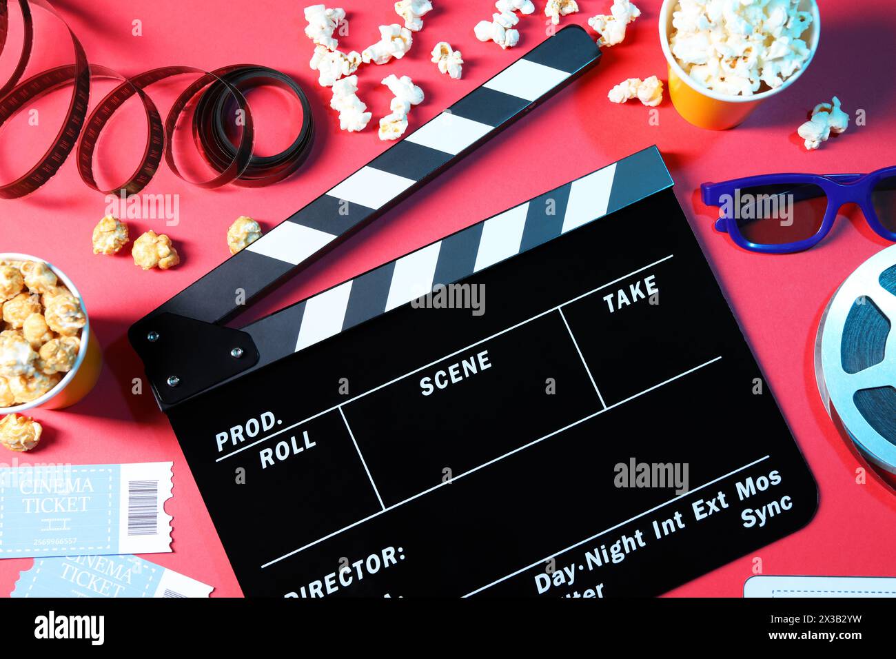 Flat lay composition with clapperboard and popcorn on red background Stock Photo