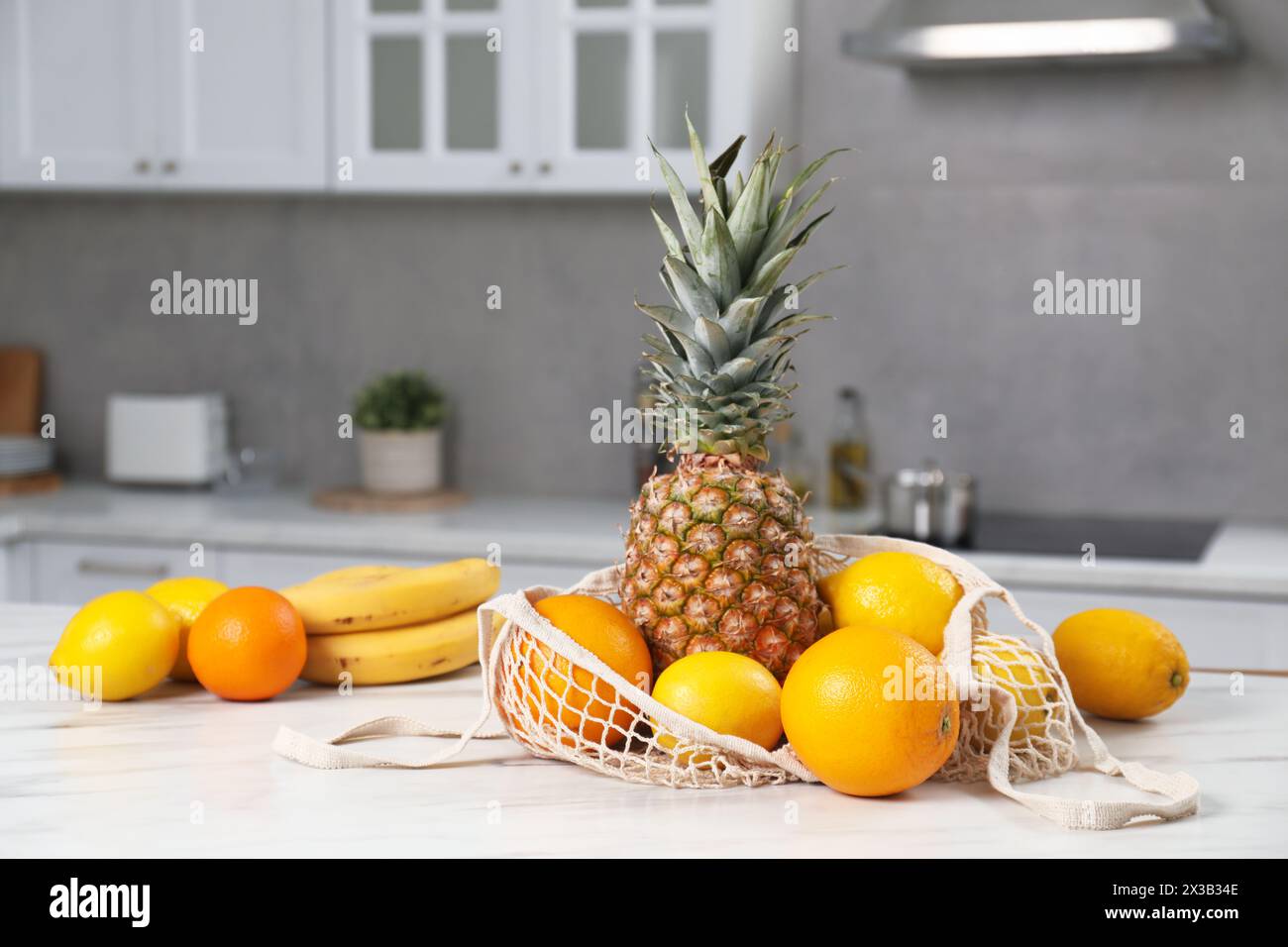 String bag with fresh fruits on light table in kitchen Stock Photo