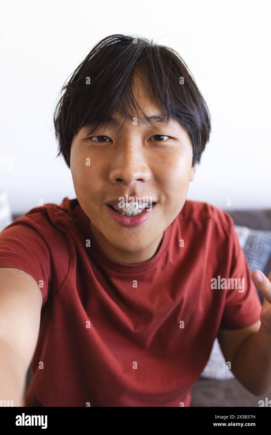teen braces selfie Asian teen boy with braces takes a selfie and video calls at home in a red  shirt Stock Photo - Alamy