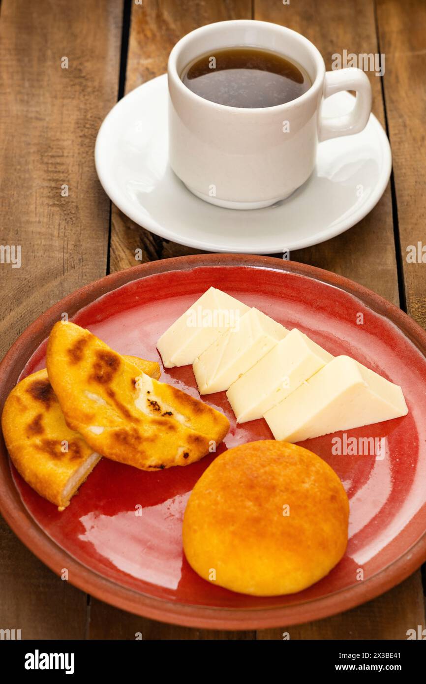 Traditional Boyacá breakfast - Arepa, almojabana, cheese and hot aguapanela Stock Photo